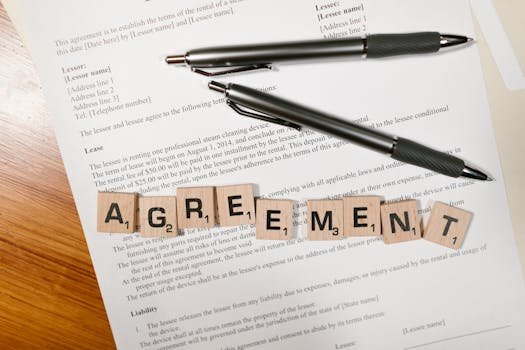 pexels-photo-7841424-7841424 A document with Scrabble tiles spelling 'AGREEMENT' and two pens, symbolizing contract signing.